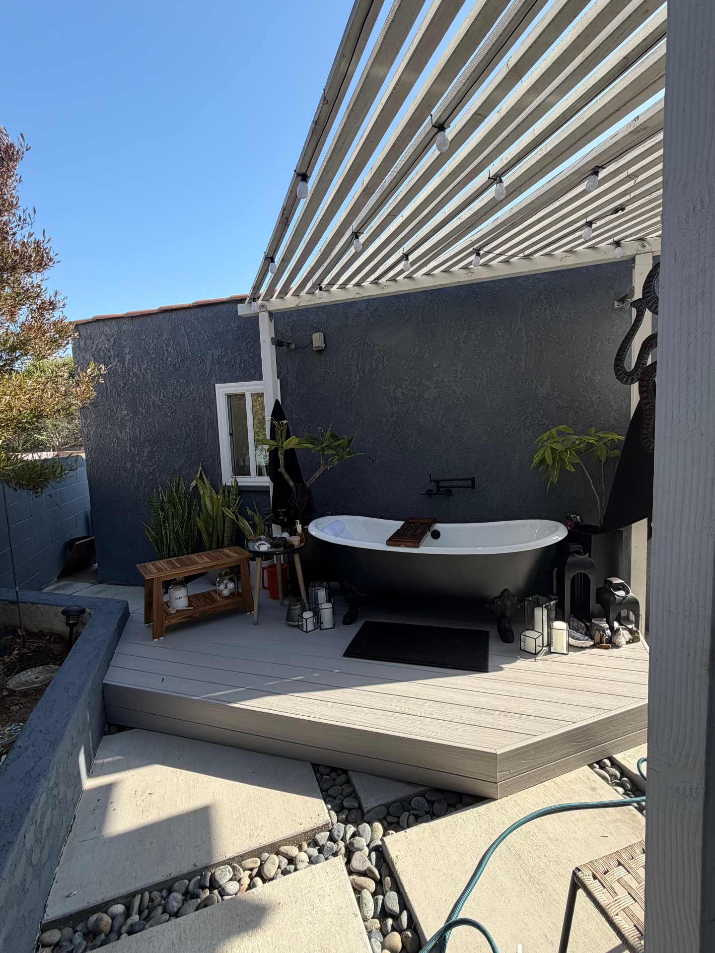 Outdoor soaking tub on a custom composite deck under a pergola